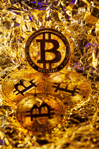 4 gold Bitcoin with golden reflect background. Great close-up shot.