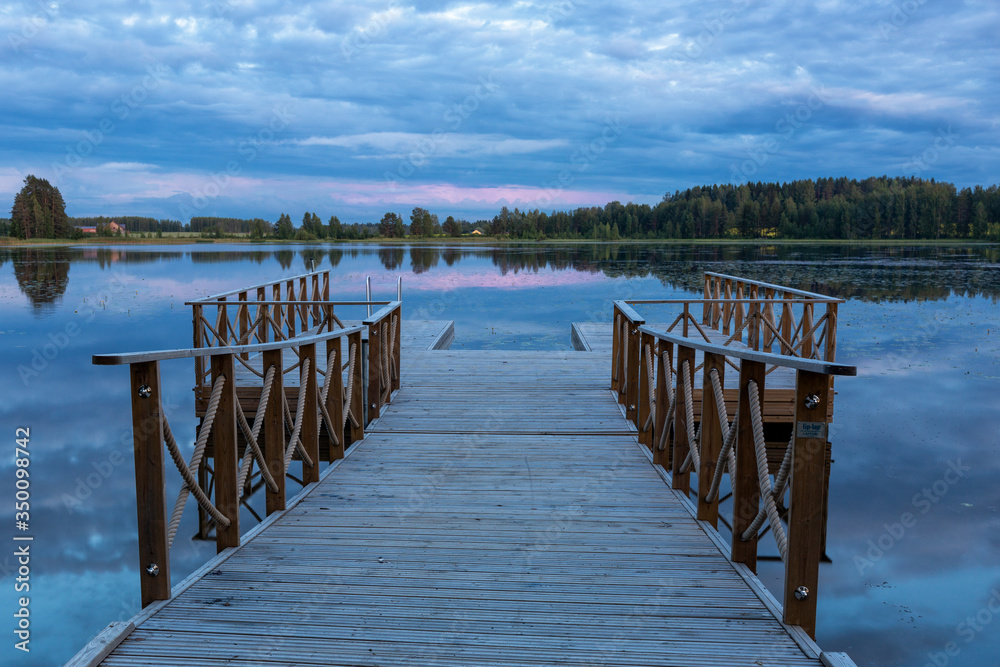 Summer evening landscape of the lake with the pier on foreground, Finland