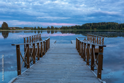 Summer evening landscape of the lake with the pier on foreground  Finland