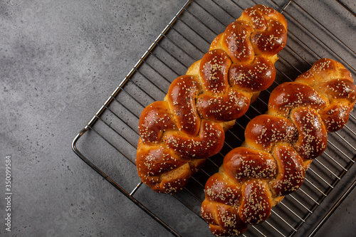 Just baked homemade Challah -  special bread in Jewish cuisine.Main ingredients are eggs, white flour, water, sugar, salt  and yeast. Decorated  with sesame and poppy seeds. Copy space. photo