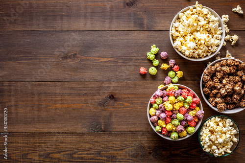 Colored popcorn in box on wooden background top view copy space