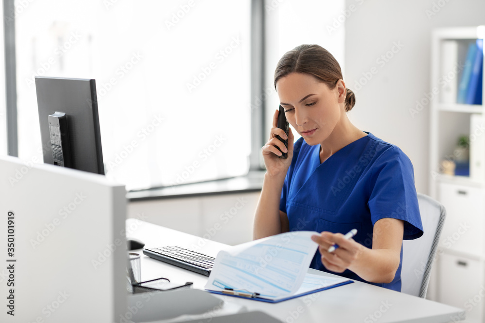 medicine, technology and healthcare concept - female doctor or nurse with computer and clipboard calling on phone at hospital medicine, technology and healthcare concept - female doctor or nurse with computer and clipboard calling on phone at hospital