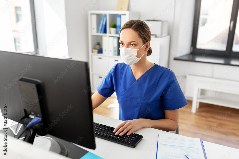 medicine, technology and healthcare concept - female doctor or nurse wearing face protective medical mask for protection from virus disease with computer working at hospital medicine, technology and healthcare concept - female doctor or nurse wearing face protective medical mask for protection from virus disease with computer working at hospital