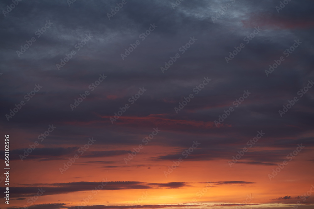 Fototapeta premium A beautiful evening blue sky at sunset with flaming bright light clouds. Warm evening.