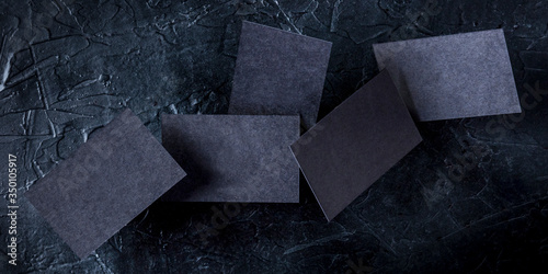 Thick black business cards panorama, flying on a dark background, a mockup for a creative design presentation