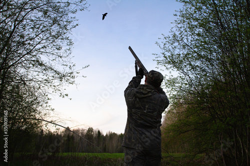 Wallpaper Mural a hunter takes aim at a flying woodcock late at night