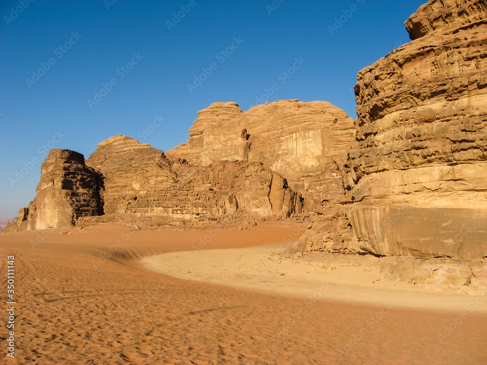 Picturesque rocks of Wadi rum in the Jordanian part of the Arabian desert among orange and yellow sand. Picturesque rocks of Wadi rum in the Jordanian part of the Arabian desert among orange and yellow sand.