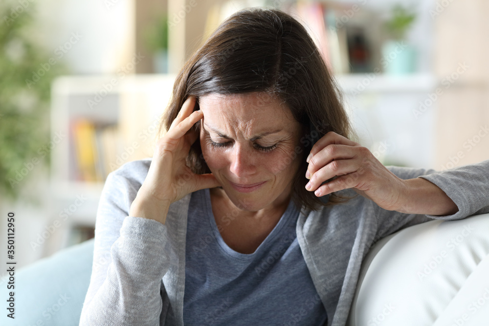 Sad middle age woman calling on phone at home