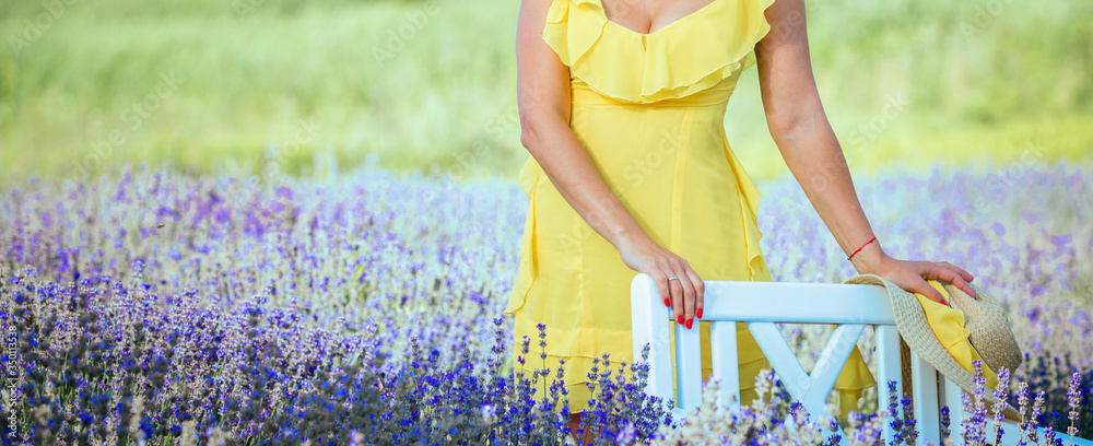 Gorgeous young girl in a yellow 
bright dress in purple lavender field. Provence, lavender, France, travel. Cosmetics and beauty. Beautiful summer concept.