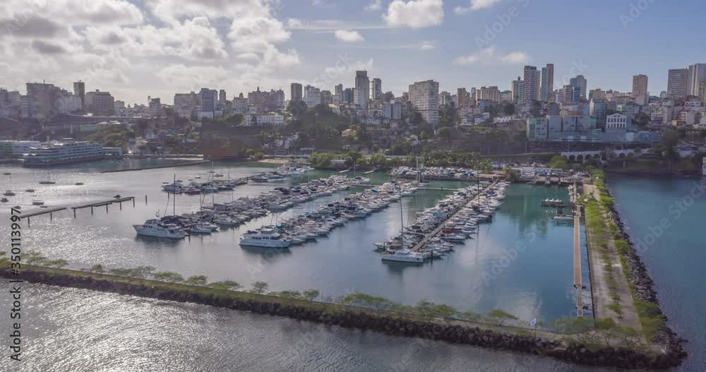 Aerial hyperlapse of boats parked in a marina with the city of Salvador in the background