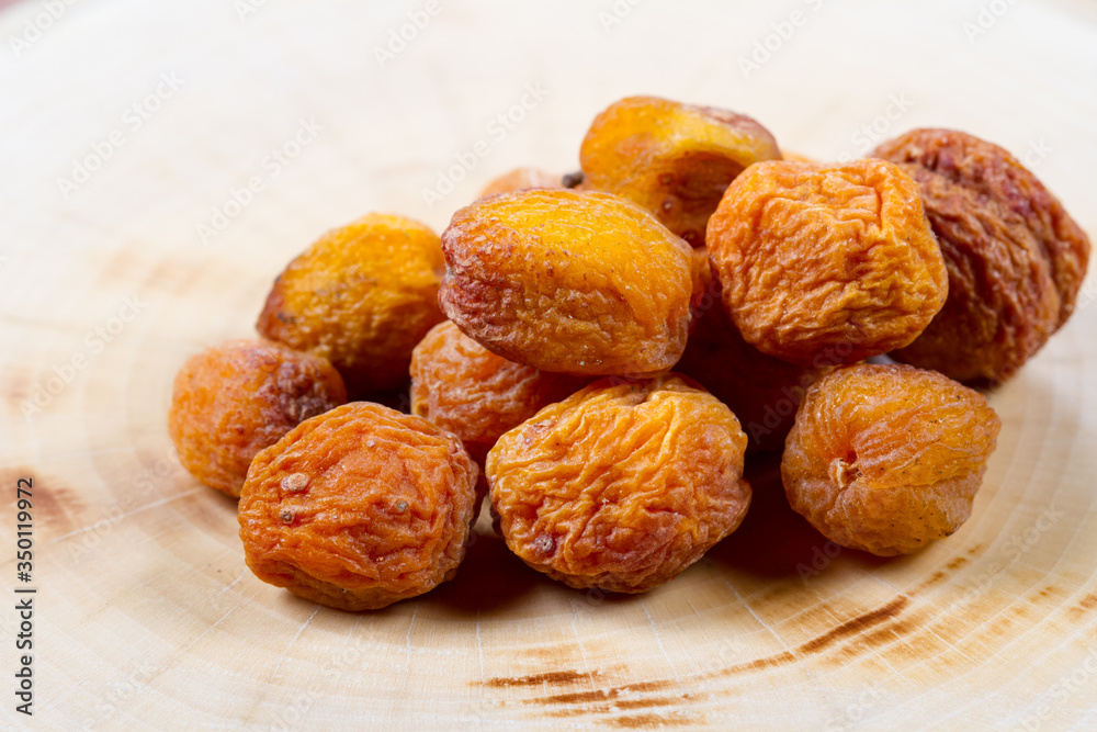Dried apricot with a bone closeup on a wooden table. Baking ingredients. Healthly food. Dried apricot with a bone closeup on a wooden table. Baking ingredients. Healthly food.