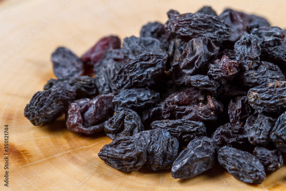 Uzbek blue raisins closeup on a wooden table. Baking ingredients. Healthly food. Uzbek blue raisins closeup on a wooden table. Baking ingredients. Healthly food.