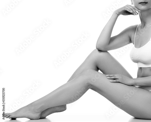 Wellness and beauty concept  beautiful slim woman in white underwear sitting on white floor.