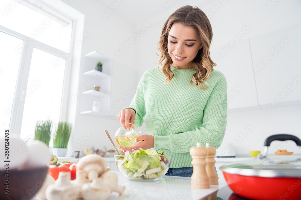 Photo of beautiful housewife hold olive oil adding to vegetable salad ingredients cooking tasty meal good mood vegan concept stand bright light kitchen indoors casual clothing Photo of beautiful housewife hold olive oil adding to vegetable salad ingredients cooking tasty meal good mood vegan concept stand bright light kitchen indoors casual clothing