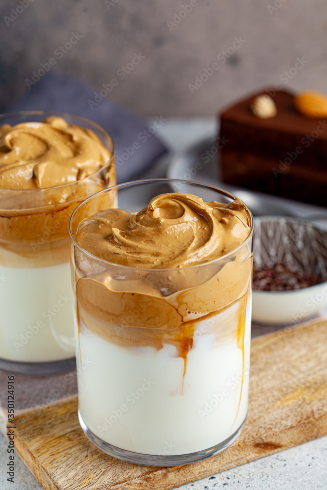Cold dalgona coffee. Korean trend drink. Drink with cold milk and coffee cream foam in glasses. Cold dalgona coffee. Korean trend drink. Drink with cold milk and coffee cream foam in glasses.