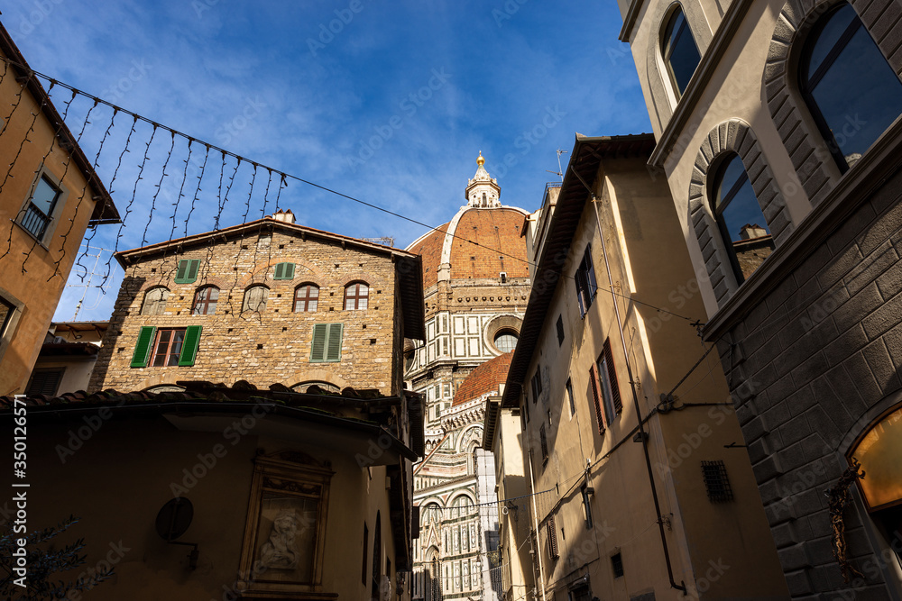 Florence Cathedral (Duomo di Firenze, Santa Maria del Fiore) with the famous dome by the architect Filippo Brunelleschi photographed from the narrow streets of the city