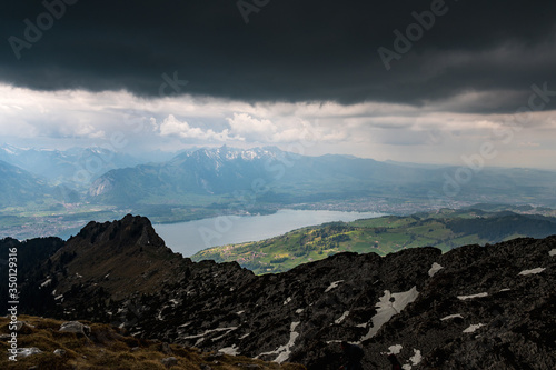 view from the peak of Sigriswiler Rothorn during a thunderstorm with Thun and Lake Thun