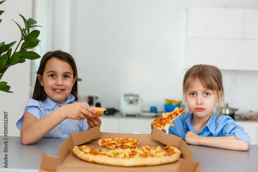 Two happy little child girl friends eating pizza slices. Two happy little child girl friends eating pizza slices.