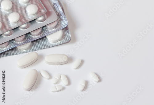 White pills in a blister pack on white background close-up. Painkillers. Protection from coronovarus Covid19. Tablet packages. Medicine for the first-aid kit.