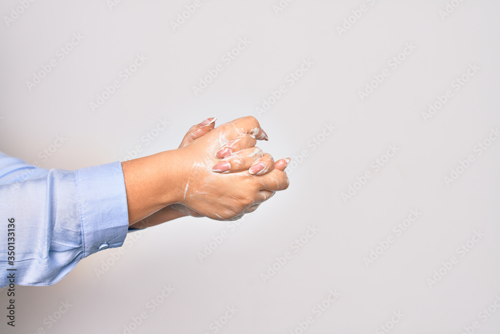 Young caucasian woman cleaning hands using alcohol liquid over isolated white background Young caucasian woman cleaning hands using alcohol liquid over isolated white background