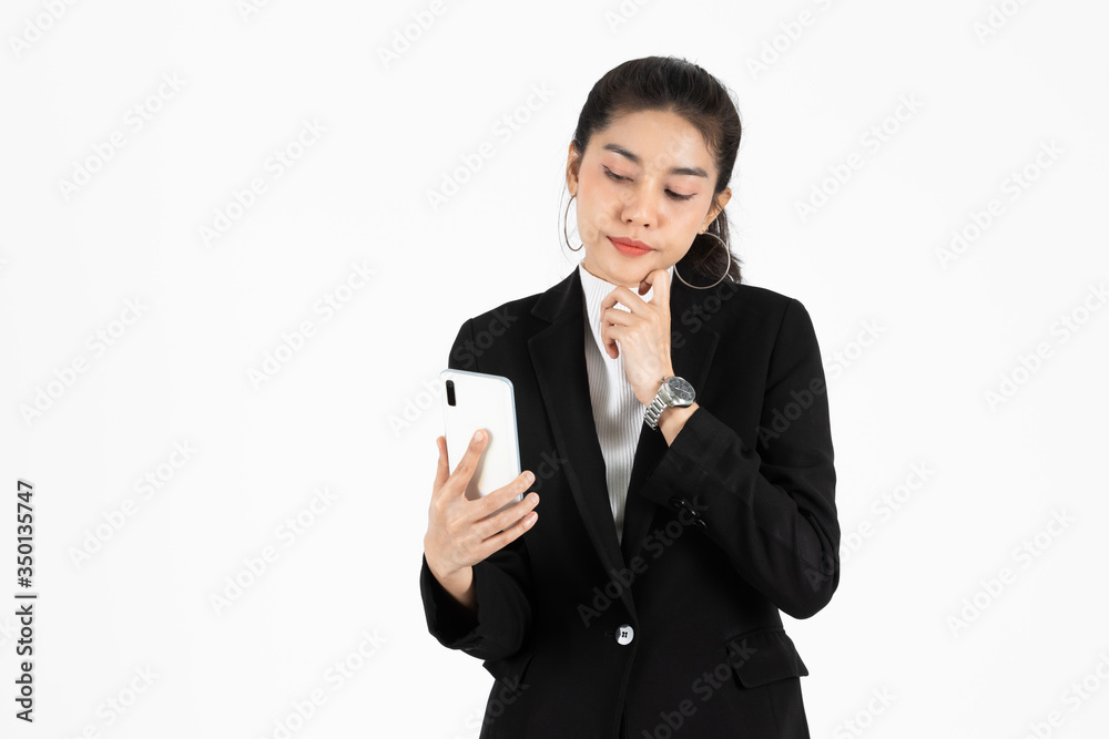 Confident young Asian business woman in suit with mobile smart phone having good idea posing over white isolated background. Think and thoughtful in business concept. Confident young Asian business woman in suit with mobile smart phone having good idea posing over white isolated background. Think and thoughtful in business concept.