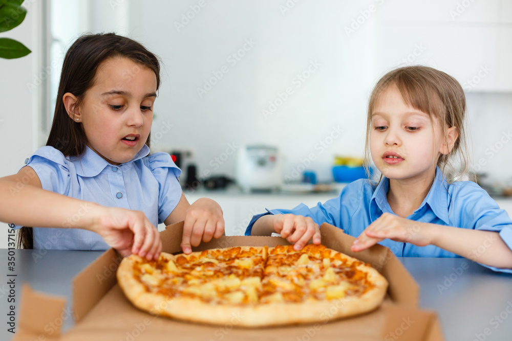 Two happy little child girl friends eating pizza slices. Two happy little child girl friends eating pizza slices.