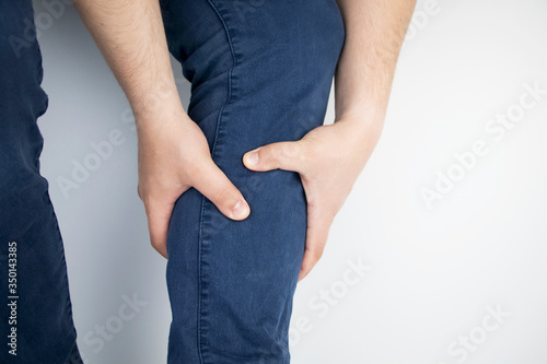 A man suffers from pain in the calves. Stretching the calf muscle, varicose veins, leg cramps, or myositis. Orthopedic doctor examines