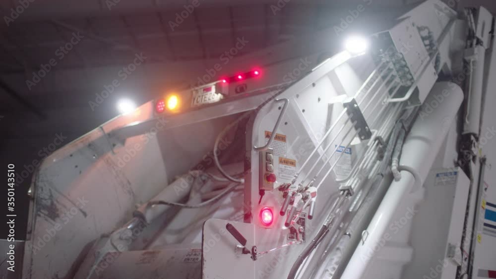 Track back from a garbage truck with warning lights flashing