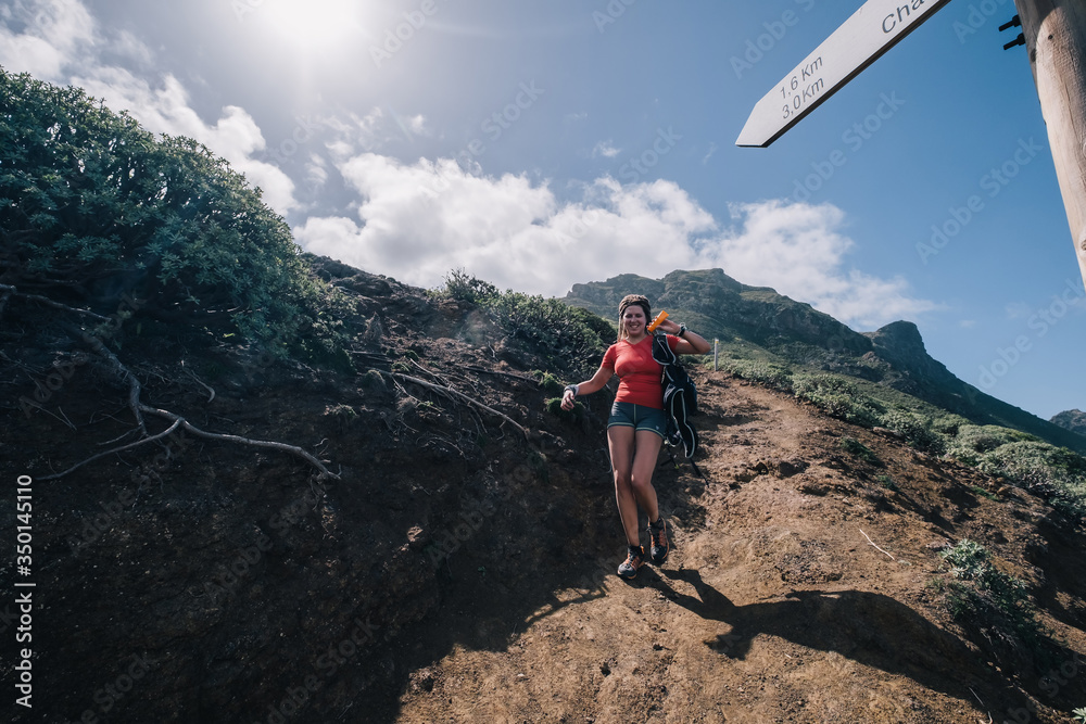 Obraz premium A strong female trail runner with majestic mountains and blue sky