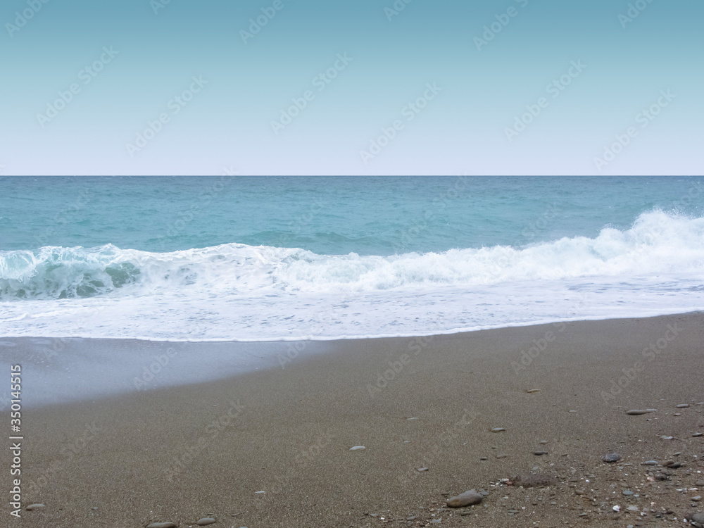 Sea coast, waves with foam, a beach with dark sand. Sea coast, waves with foam, a beach with dark sand.