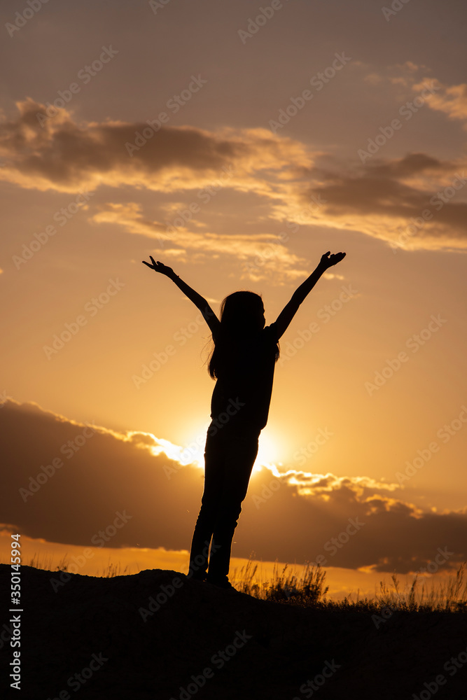 Silhouettes of girls with hands up in the field on a sunset background. Silhouettes of girls with hands up in the field on a sunset background.
