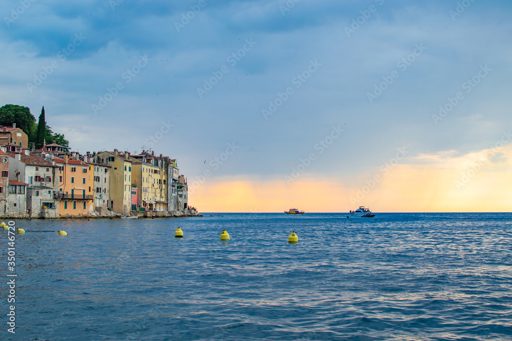 View of the horizon over the Adriatic Sea, with the typical croatian old houses in the coastline of the old town of Rovinj, Croatia, during the sunset