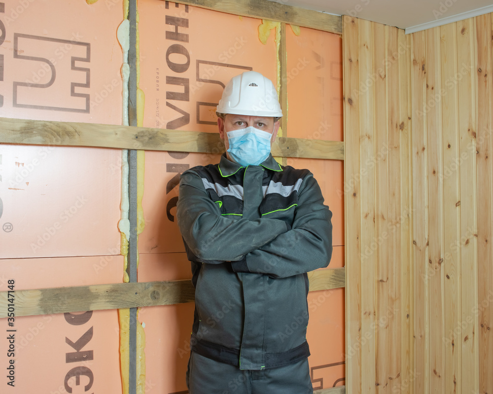 Construction worker wearing a medical mask, uniform and white helmets to protect against coronovirus Construction worker wearing a medical mask, uniform and white helmets to protect against coronovirus