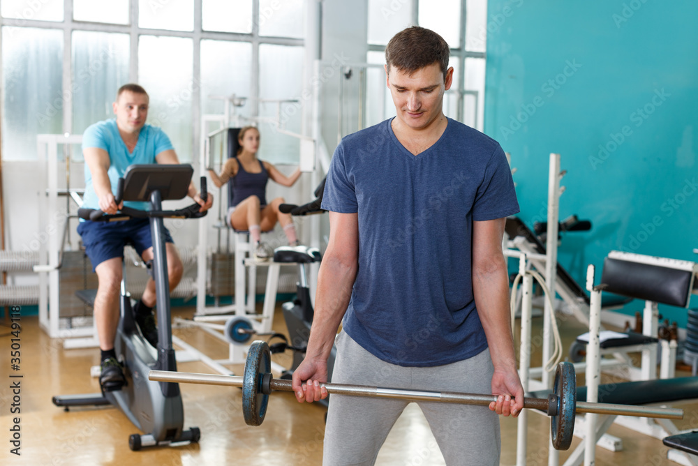 Fototapeta premium Man doing exercises with barbell