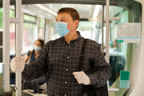 Passenger in disposable mask in city streetcar © JackF