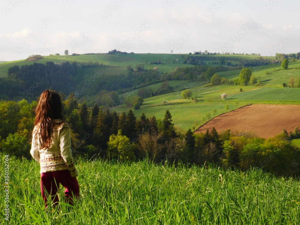 Little girl between 6 and 8 years old seen from behind staring up at the hill Little girl between 6 and 8 years old seen from behind staring up at the hill