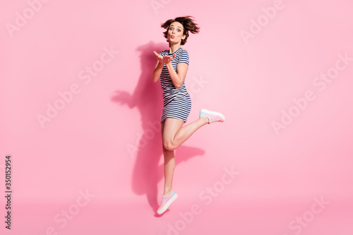 Full body profile photo of attractive lady jumping high up rejoicing sending air kisses boyfriend wear casual white blue summer dress shoes isolated pastel pink color background