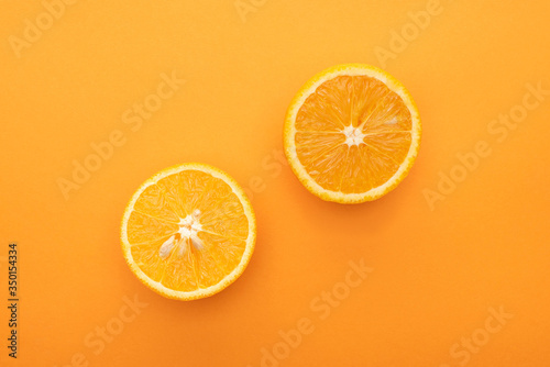 top view of juicy orange slices on colorful background