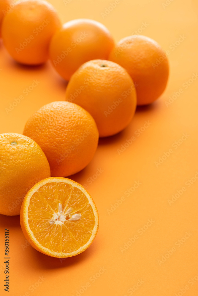 selective focus of ripe juicy whole and cut oranges on colorful background selective focus of ripe juicy whole and cut oranges on colorful background