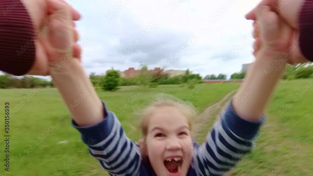 Dad turns daughter holding hands. cheerful child, happy childhood Dad turns daughter holding hands. cheerful child, happy childhood