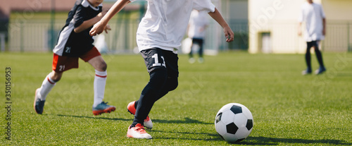 Junior soccer players on a game. European football tournament match between young footballers