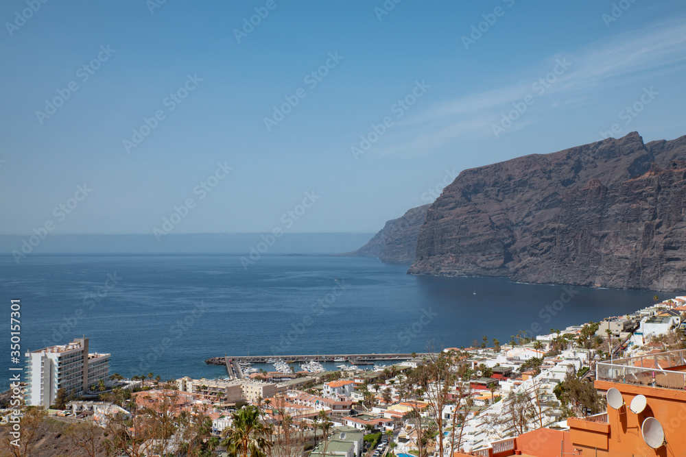 Acantillados de Los Gigantes or simply Los Gigantes, giant cliffs at the edge of Atlantic Ocean and the quaint village and resort as seen from an elevated viewpoint, Tenerife, Canary Islands, Spain