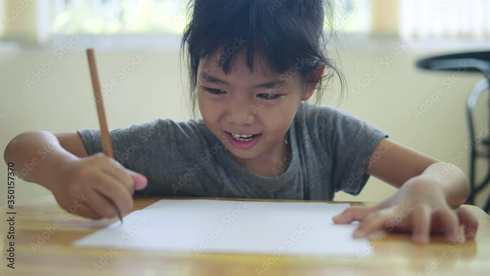 Thai girl learning and drawing line on white paper in slow motion. Child happy and smiling in 4K resolution Thai girl learning and drawing line on white paper in slow motion. Child happy and smiling in 4K resolution