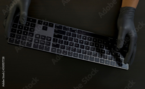 Holding wireless keyboard with glove. photo