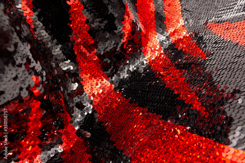Texture of red and black sequins on a modern, elegant, evening dress. The concept of a glamorous background.
