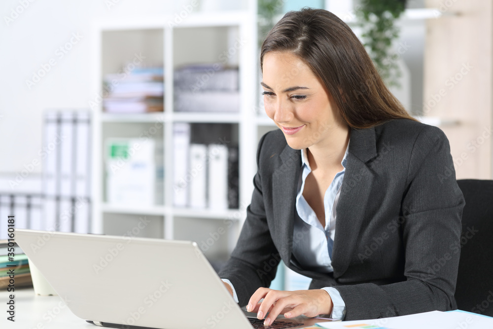Executive woman working on laptop sitting at office Executive woman working on laptop sitting at office