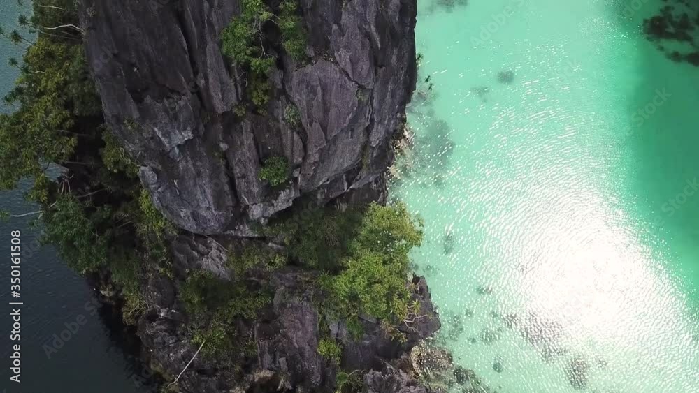 Tilt Up Aerial View of Steep Cliff Dividing Two Majestic Tropical Lagoon in El Nido, Palawan Island, Philippines Tilt Up Aerial View of Steep Cliff Dividing Two Majestic Tropical Lagoon in El Nido, Palawan Island, Philippines