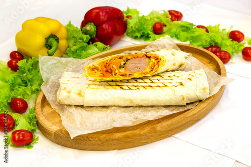 Shawarma, meat kebab on a plate with vegetables, traditional meat food in pita bread