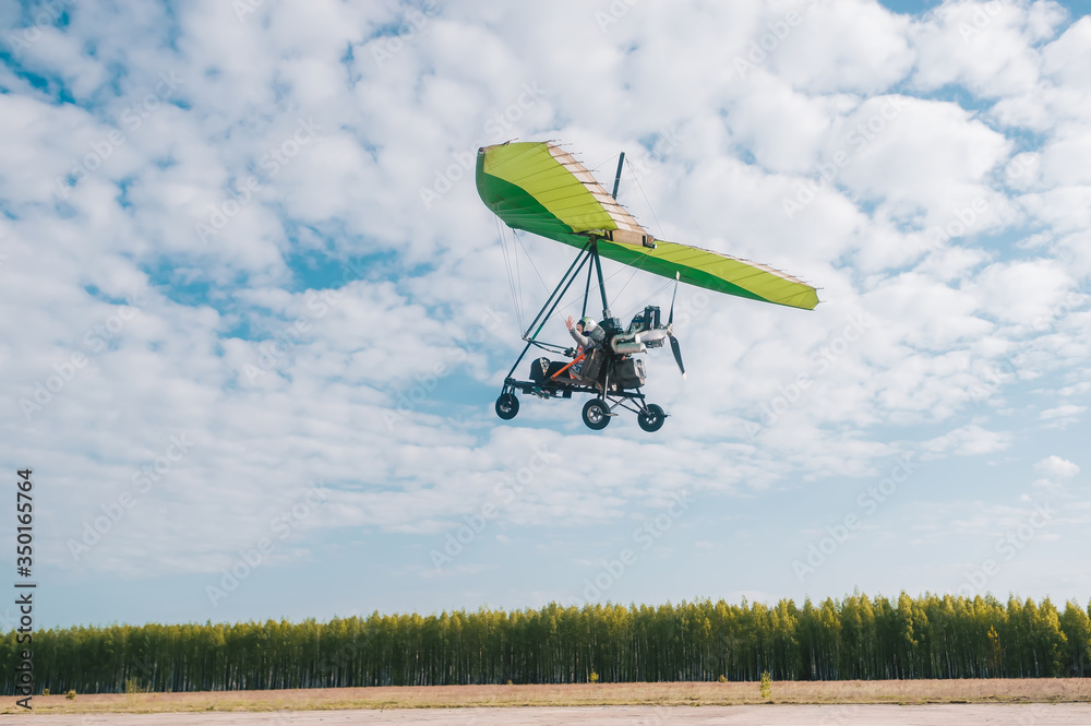 The motor hang-gliding in the sky with clouds
