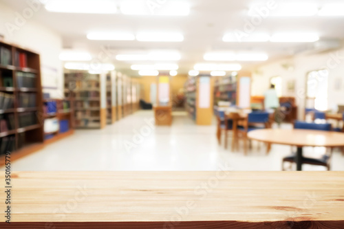 Empty wooden desk space platform with library background for product display montage. Education concept.
